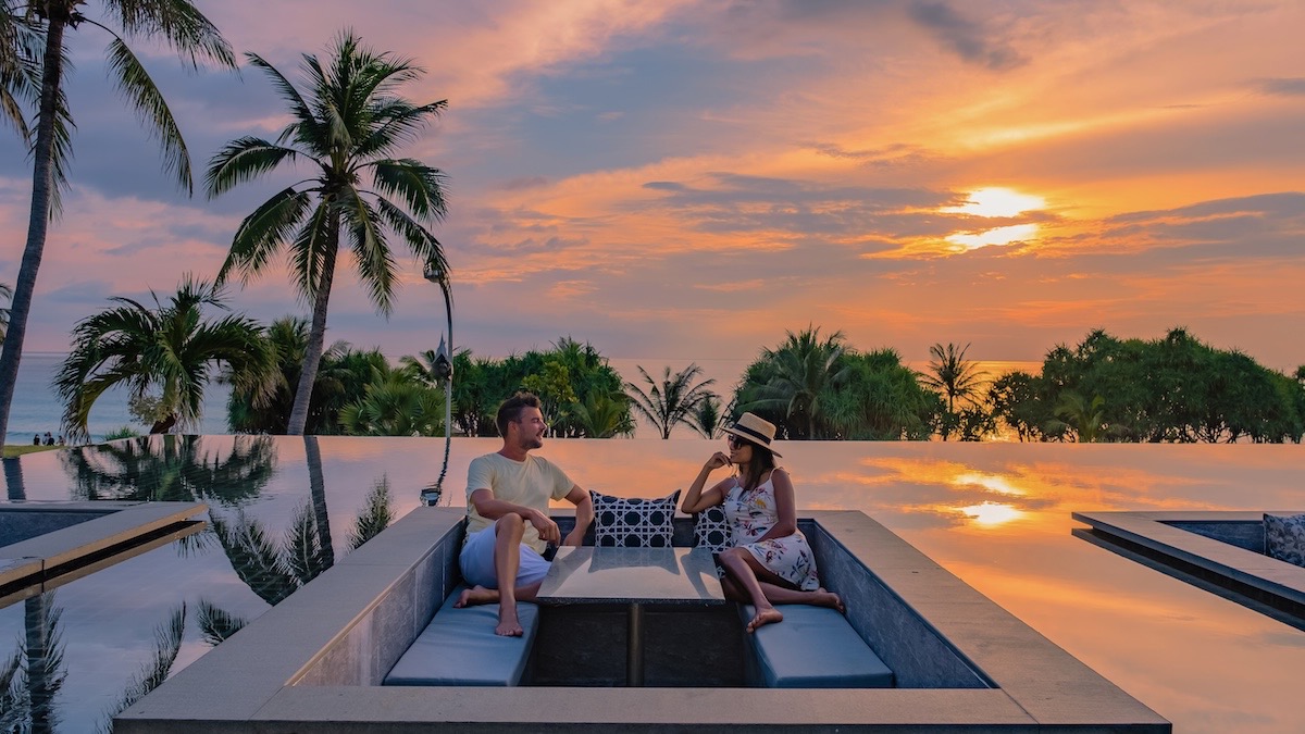 A couple enjoying an oceanfront pool — explore LP Luxury club membership